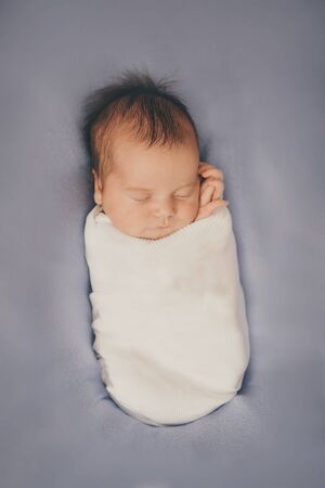 newborn baby sleeps wrapped in a blanket. concept of childhood, healthcare, IVFの写真素材