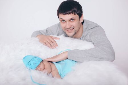 the concept of parenthood, children's Day, medicine, IVF-father looks at the sleeping newborn and stroking it. Isolated on white background.の写真素材