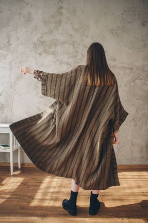 beautiful caucasian woman in Japanese kimono and black shoes on the background of the home interior. Model advertising clothesの写真素材