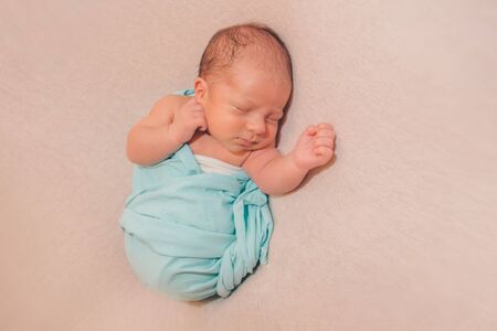 newborn baby sleeps wrapped in a blanket. concept of childhood, healthcare, IVFの写真素材