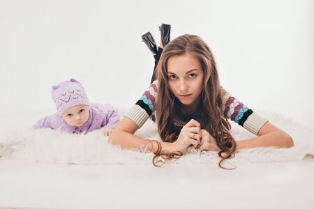 the concept of a healthy lifestyle, the protection of children, shopping - a teenager with a newborn baby playing together. Happy kids: brother and sister on white backgroundの写真素材