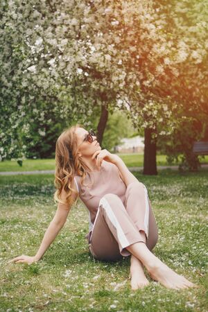 fashionista in dark glasses walking in the Park barefoot. Beautiful girl in natureの写真素材