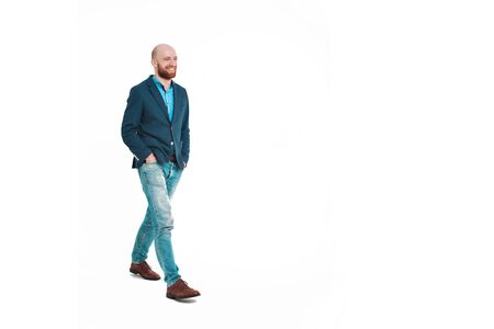 businessman on a walk after a successful transaction. Smiling bald guy. Isolated on white background.の写真素材