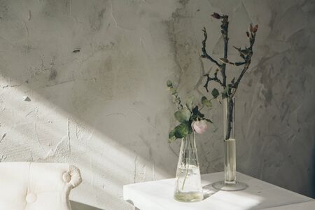 flowers in a vase on the table in a cozy room with a sofa. The concept of simple interior...