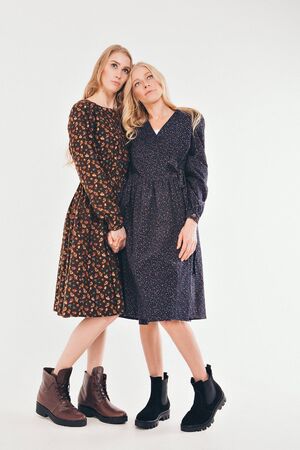 advertising of fashion for woman: dress, shoes. two happy girls smiling. Portrait of women hugging. The concept of relationships in the family, friends, sisters, couple in love. isolated on white background.の写真素材