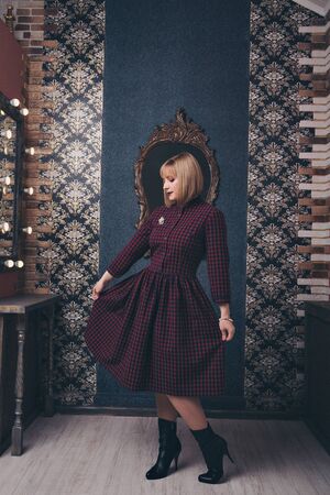 fashionable stylish portrait of a woman with white short hair. model in a purple dress with a brooch near the mirror. work concept, model businessの写真素材