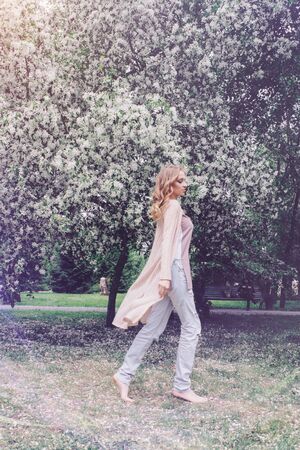girl walking in the Park among the flowering trees. Spring mood-a woman in natureの写真素材