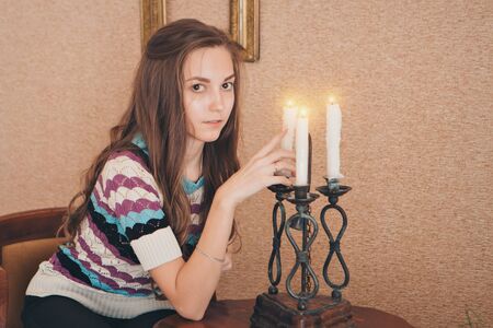 portrait of a girl with a candle. Concept of religious holidays, alternative lightingの写真素材