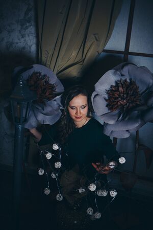 beautiful girl among the flowers and lantern in the shade. Spring mood-a woman in a fairy-tale worldの写真素材