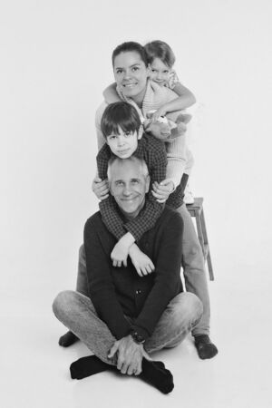 A group of smiling people formed a column. Happy man among women: adults, children, toy. Gift concept for children, family dayの写真素材