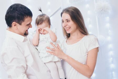 family photo on a white background: parents spend time with their children. mom and dad hug the baby. the concept of childhood, fatherhood, motherhood, IVFの写真素材