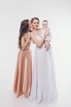 wedding fashion concept for women of all ages. A group of women in long evening dresses on a white backgroundの写真素材