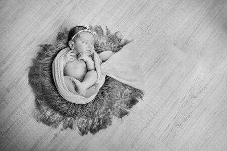 newborn baby wrapped in a blanket sleeping in a basket. concept of childhood, healthcare, IVF. Black...