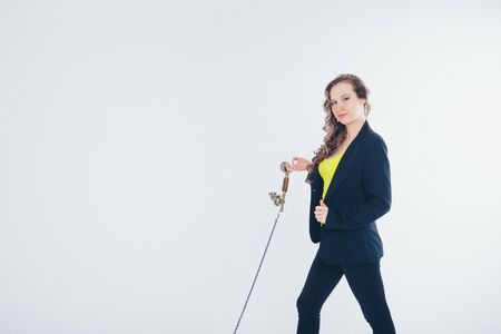 the concept of work in the office, business plan, fashion-a happy businesswoman in a black and yellow suit smiling into the phone. Beautiful woman on white backgroundの写真素材
