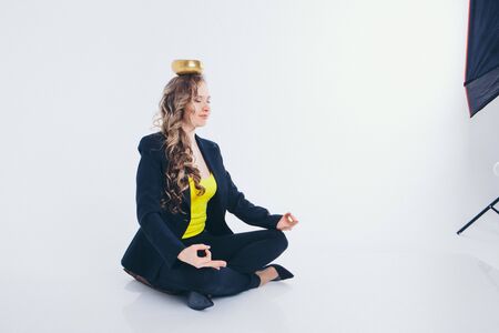 businesswoman meditating. Preparation of a potion on a white background. Singing bowl with Buddhist mantra in woman's hand in a suitの写真素材