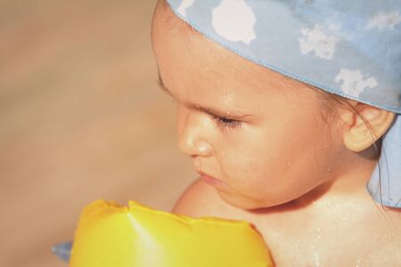 portrait of a girl in the armrests and a bathing cap on vacation. The concept of equipment for...