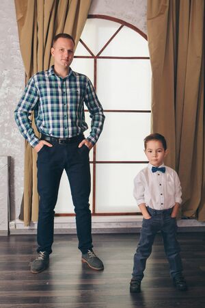 two men in identical poses. Father and son. Business development concept, demonstration of strength, continuityの写真素材