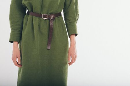advertising women's fashion: green dress, suit. female hands, the strap and sleeve closeup. The ornament of clothing, seams, stitchの写真素材