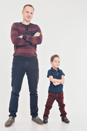 two men in identical poses. Father and son. Business development concept, demonstration of strength, continuityの写真素材