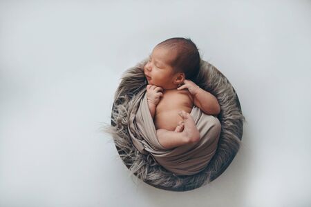 newborn baby wrapped in a blanket sleeping in a basket. concept of childhood, healthcare, IVF. Black...