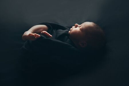 the concept of healthy lifestyle, IVF - a newborn baby sleeps under a blanket. Head, legs and armsの写真素材