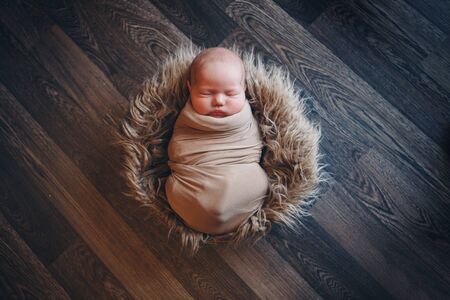newborn baby wrapped in a blanket sleeping in a basket. concept of childhood, healthcare, IVF. Black and white photoの写真素材
