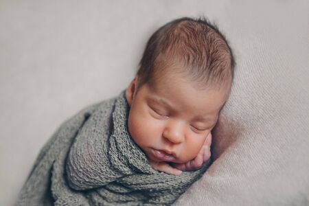 the concept of healthy lifestyle, IVF - a newborn baby sleeps under a blanket. Head, legs and armsの写真素材