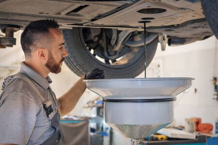 Car repair and cleaning concept - car engine close-up, wiping parts under the hoodの写真素材