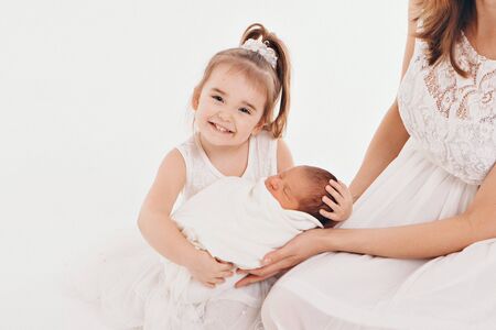 family photo on a white background: woman and boy spend time with children. hug the baby. the concept of childhood, fatherhood, motherhood, IVFの写真素材