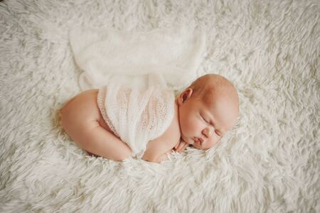 the concept of healthy lifestyle, IVF - a newborn baby sleeps under a blanket. Head, legs and armsの写真素材