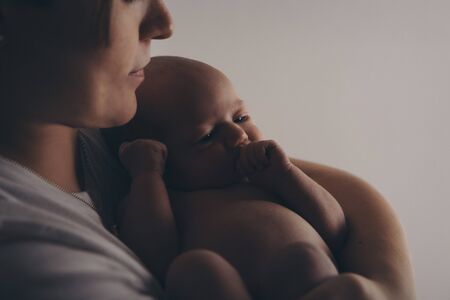 photo in black and white: the mother holds her son in her arms. Family portrait: a woman with a child. Health care concept: healthy familyの写真素材
