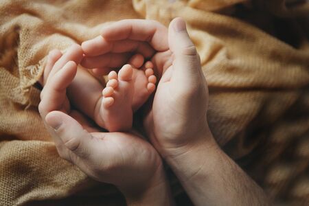 Newborn Baby's feet.Mother holding newborn baby legs,legs massageの写真素材