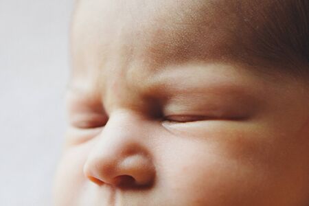 newborn baby's face close up: eyes, nose. concept of childhood, health care, IVF, hygiene