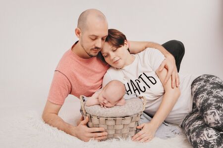 family photo on a white background: parents spend time with their children. mom and dad hug the baby. the concept of childhood, fatherhood, motherhood, IVFの写真素材