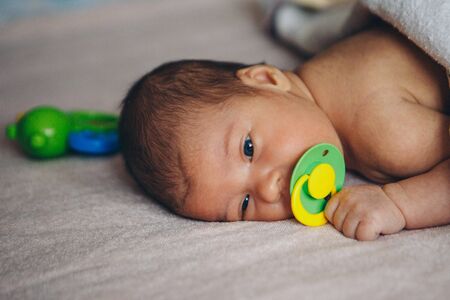 sleeping newborn baby wrapped in a blanket with a pacifier in his mouth. Health, IVF