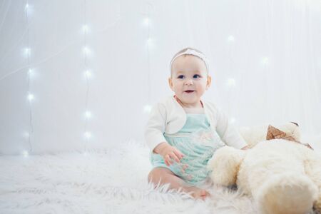 a small child with toy Taddy bear. Girl playing on white background. Concept of gift, childhoodの写真素材