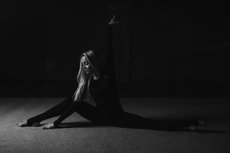 The woman sat down on the twine. classes in the fitness club. the girl is engaged in recreational gymnastics. sports exercises and stretching: athleticsの写真素材