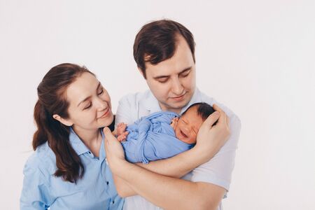the concept of a healthy lifestyle, the protection of children, shopping - baby in the arms of the mother and wather. Woman and man holding a childの写真素材