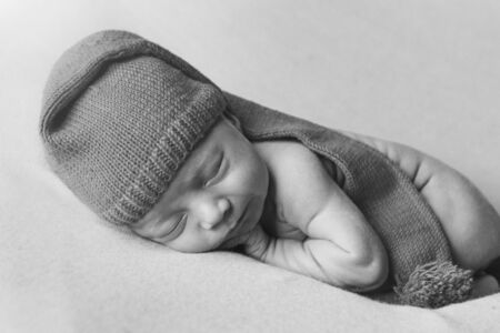 a newborn baby sleeps in a Christmas hat on a white background. the concept of a healthy lifestyle,...