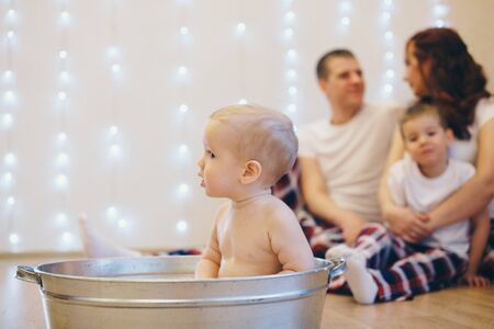 A little girl is bathing in a bath. A child washes in a basin s. concept of childhood, health care,...