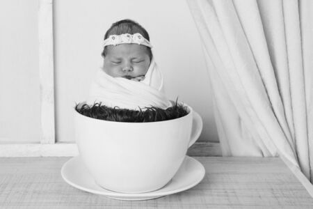 newborn baby in a large tea Cup.の写真素材