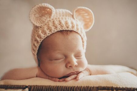 a newborn baby in a knitted hat with ears. Imitation of a baby in the womb. Portrait of a newborn.. The concept of health , parenting, children's Day, medicine, IVFの写真素材