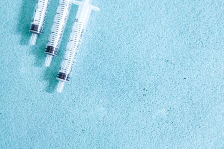 syringe on blue background. three of the medical device. Concept of vaccination, quarantine, self-isolation, protection from virus, fear of disease, treatment, medicine. copy Spaceの写真素材