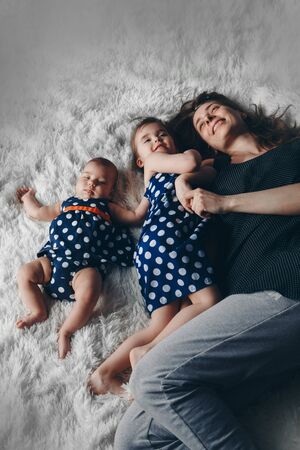 the concept of a healthy lifestyle, the protection of children, shopping - mother with two little girls lying on the floor. Woman hugging a childs.の写真素材