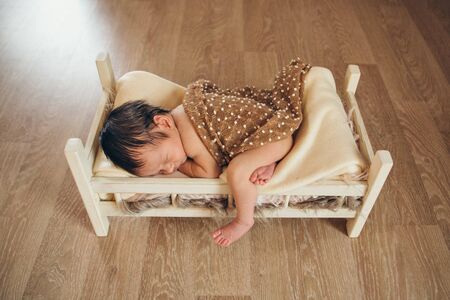 baby lying in a wooden bed under a blanket. portrait of little child. the concept of childhood, health, IVF, children's furniture, interior, wood productsの写真素材