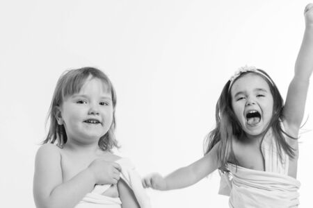 two little girls dancing on a white background. Children have fun. the concept of celebration, fun, recreation, childhood, friendship. Copy spaceの写真素材
