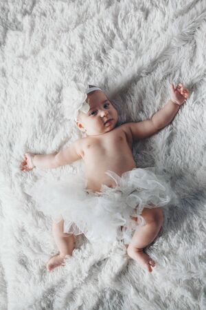 Newborn baby in white cloth lying. Imitation of baby in womb. beautiful little girl sleeping on her back. manifestation of love. Health care concept, parenthood, children's Day, medicine, IVFの写真素材