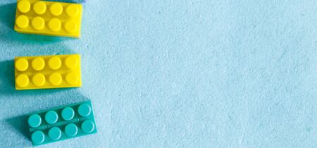 multi-colored parts of constructor. rectangular toys on a blue background. Concept of fine motor...