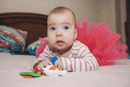 portrait of a child with a baby rattle. the girl is playing. Concept of fine motor skills development, educational games, childhood, children's day, kindergarten copyspaceの写真素材