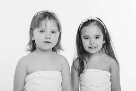 a little girls grimaces against a white background. The children is up to something. Concept of emotions , facial expressions, childhood, sincerityの写真素材